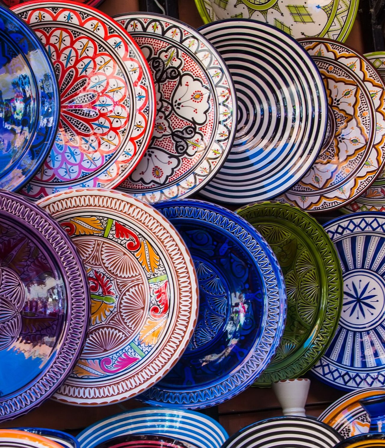 Diversa cerámica tradicional marroquí, cada plato con colores vivos y patrones cautivadores y simétricos