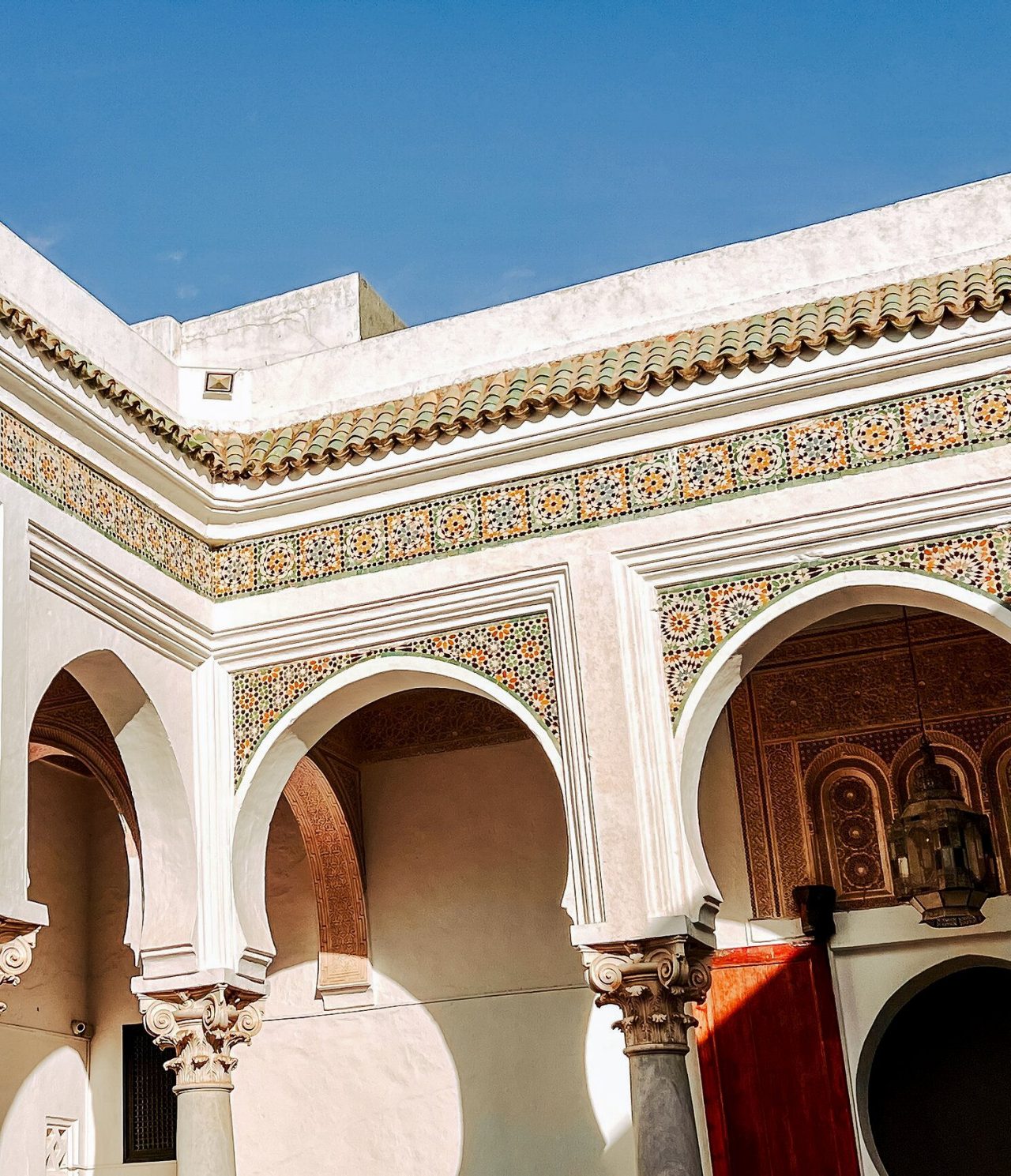 Patio interior de un edificio tradicional marroquí, con varios patrones simétricos y coloridos en las paredes