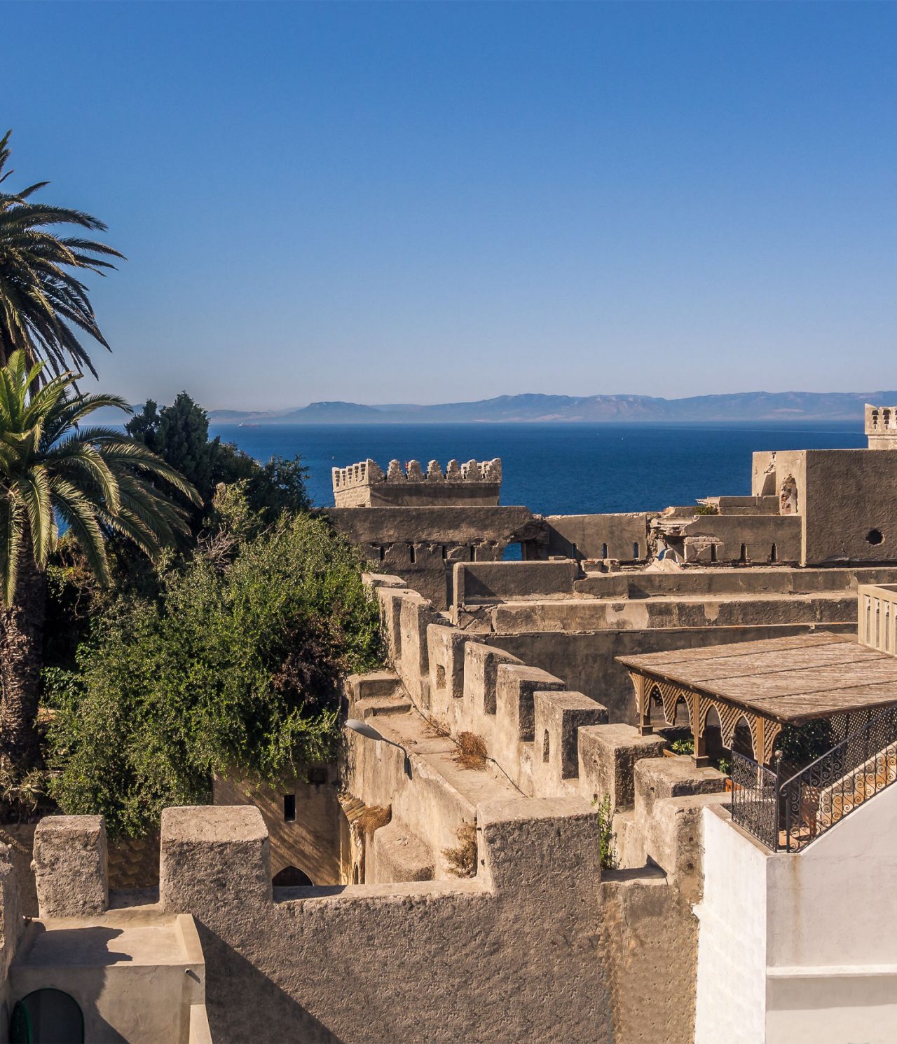 Edificios históricos en Tánger, con murallas y árboles en su interior, con vista al mar