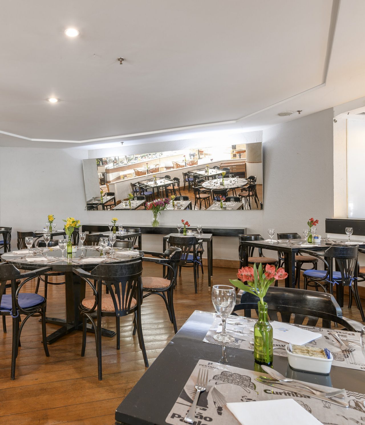 The Cais da REl restaurante Cais da Ribeira, del Hotel en el Centro de São Paulo, tiene un espacio con sillas y mesas y un espejo grandeibeira restaurant, at the Hotel in central São Paulo, has a spacious area with tables and chairs and a mirror