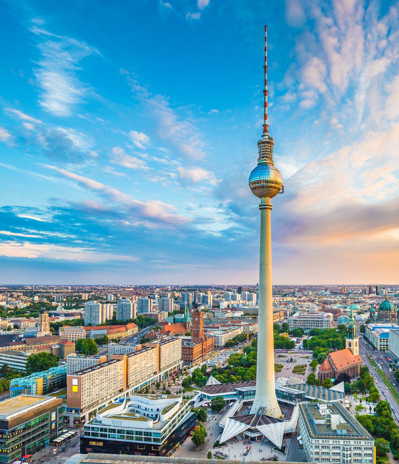 Explora Hoteles en Berlín con vistas aéreas de la Torre de Televisión y el horizonte urbano al atardecer