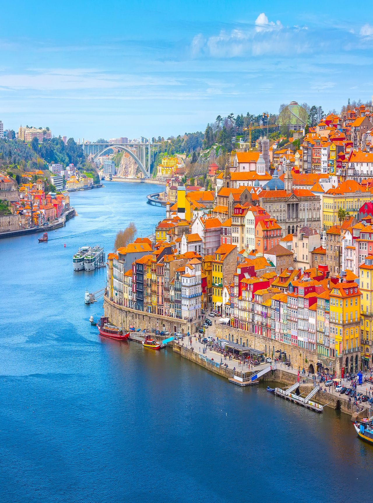 Personas disfrutando de la vista de Ribeiro do Porto, un lugar histórico y turístico sobre el río Duero y Puente Dom Luís I