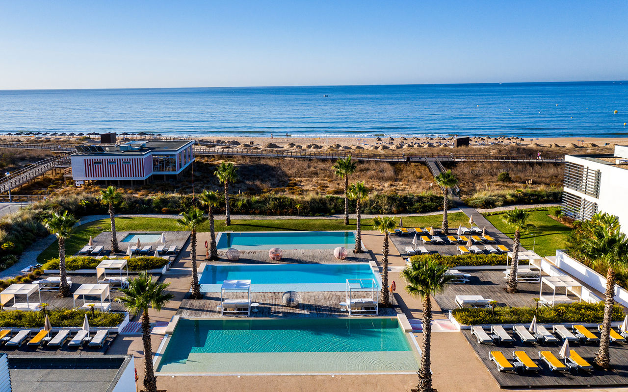 Área exterior de piscinas y tumbonas de Pestana Alvor South Beach, con acceso directo a la playa