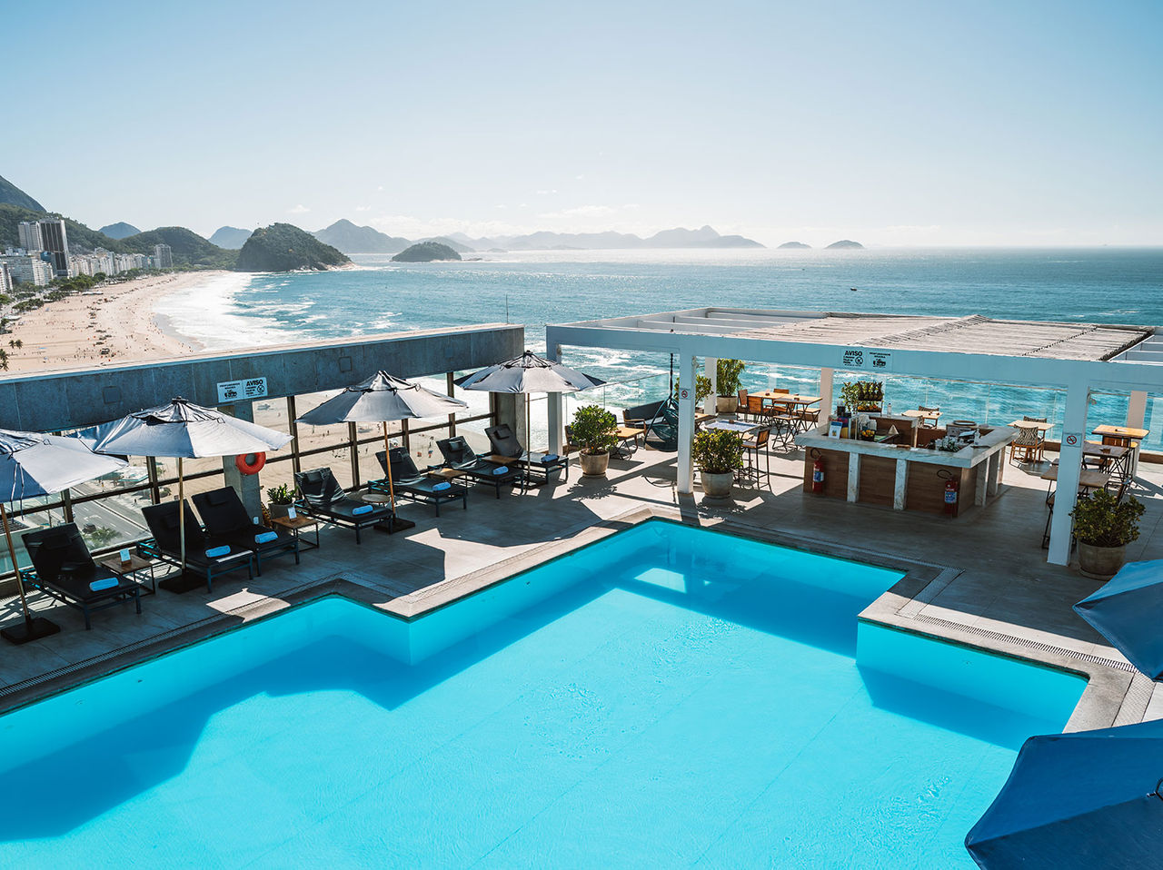 Bar do Pestana Rio Atlântica, Hotel Junto à Praia de Copacabana, com piscina e vista para o mar e orla ao fundo