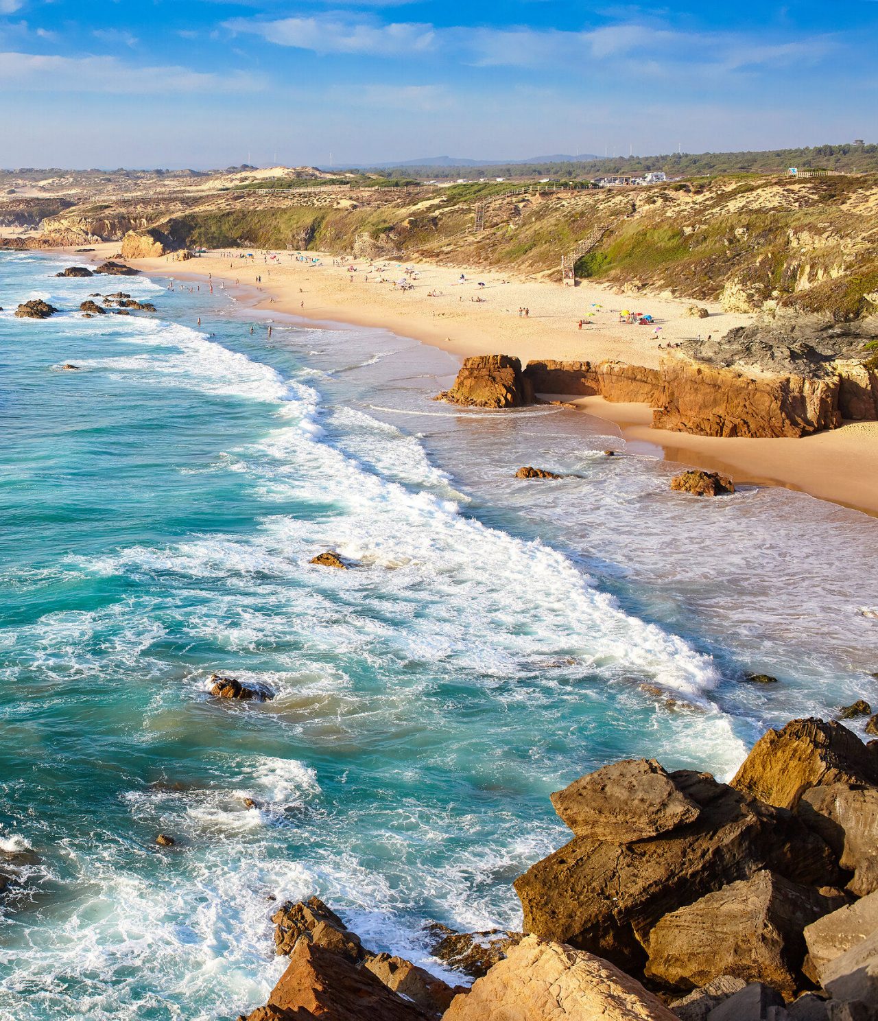 Praia escondida entre falésias no Alentejo, com águas cristalinas e areia branca, ideal para relaxar