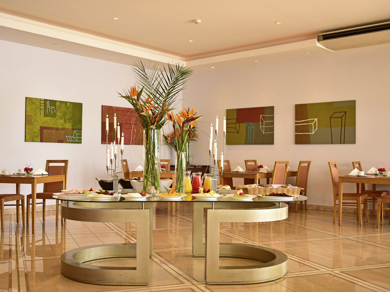 O Restaurante A Adega, Aparthotel no Algarve, tem várias mesas postas com decoração, comida e flores no centro