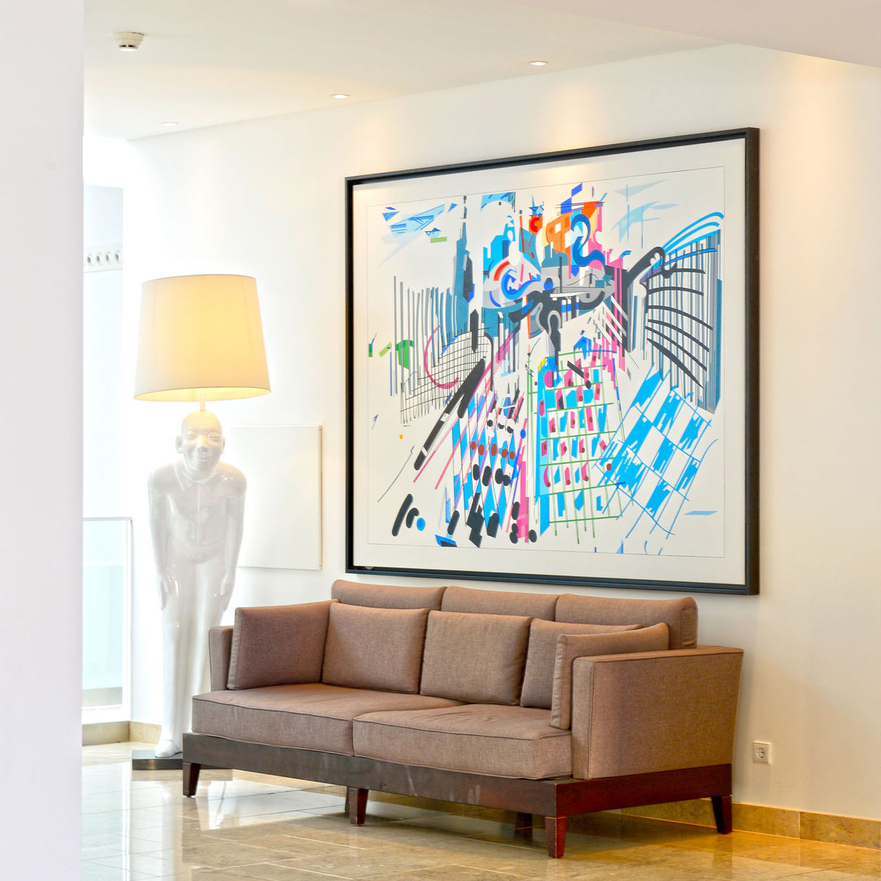 Lobby de Hotel com Spa e piscina, com luz natural e decoração moderna, com um quadro colorido e um candeeiro em forma humana