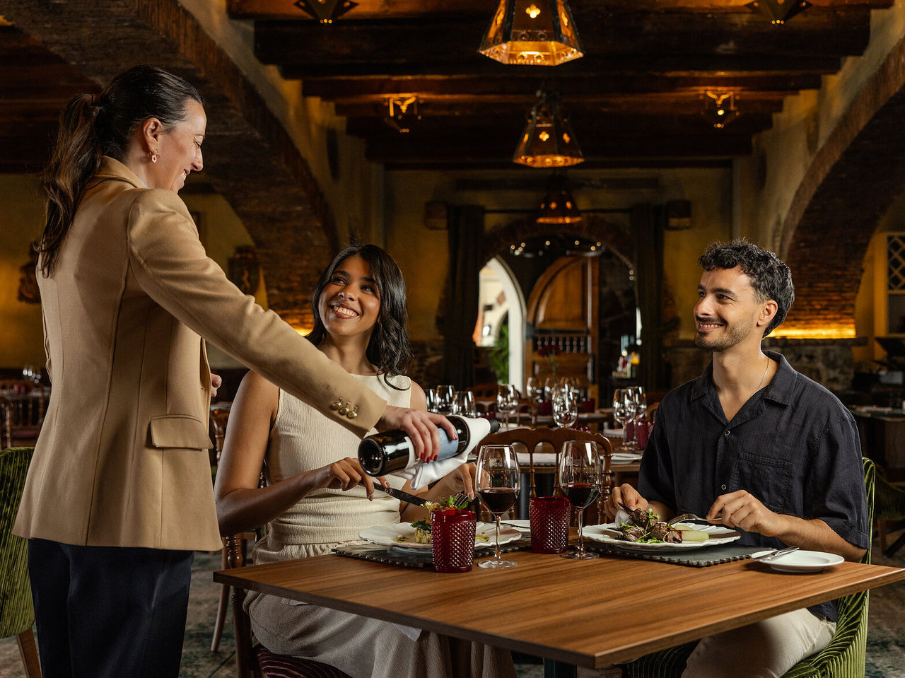 Restaurante do Pestana Carlton Madeira Hotel 5 Estrelas na Madeira, casal janta em salão rústico iluminado