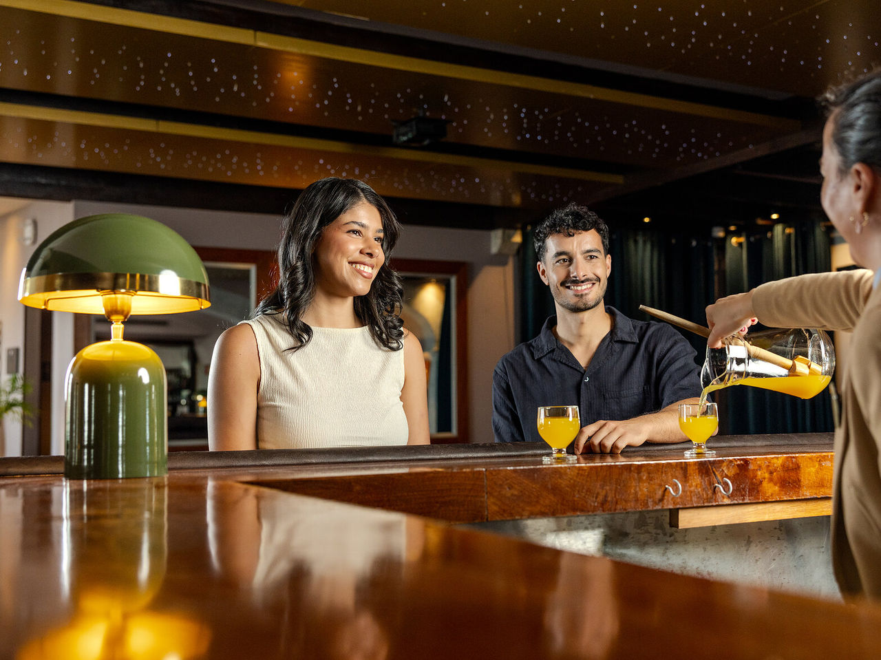 Bar do Pestana Carlton Madeira Hotel 5 Estrelas na Madeira, hóspedes brindando com bebidas no balcão