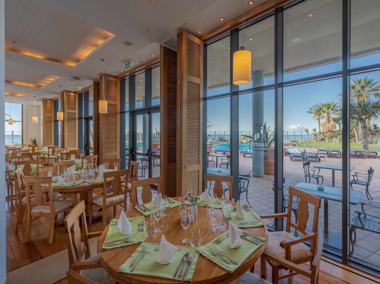 O restaurante Cabo Girão, do Hotel 5 Estrelas no Funchal, na Madeira, tem uma sala com mesas com talheres e vista para o mar