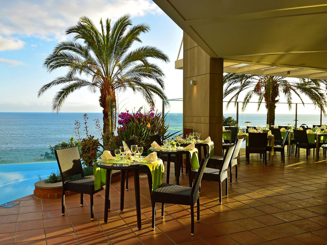 O restaurante The Deck, do Hotel 4 Estrelas Junto ao Mar no Funchal, tem várias mesas com vista para a piscina e para o mar