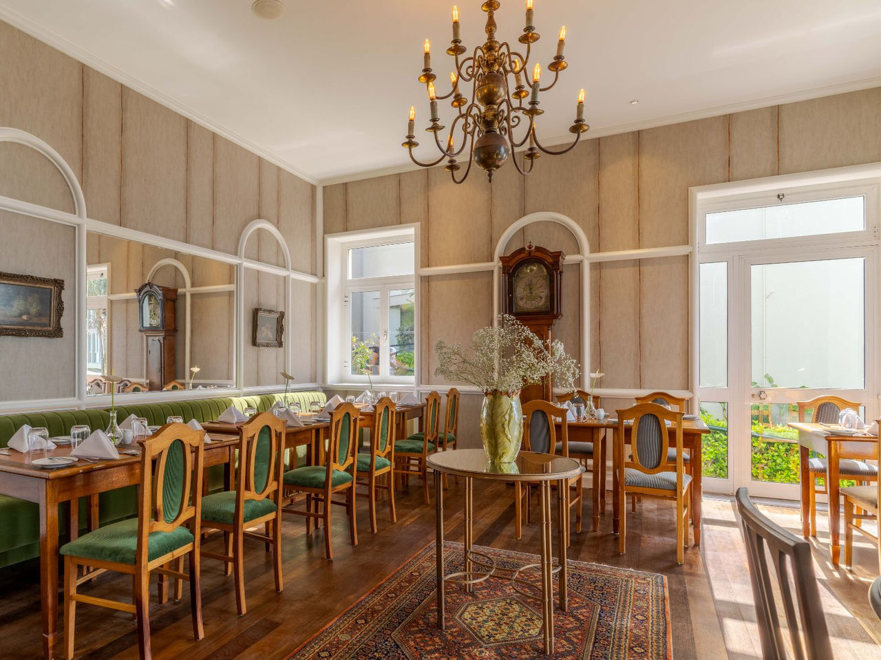 O Restaurante Vila Lido, do Hotel com Acesso ao Mar no Funchal, tem papel de parede às riscas, janelas e cadeiras 