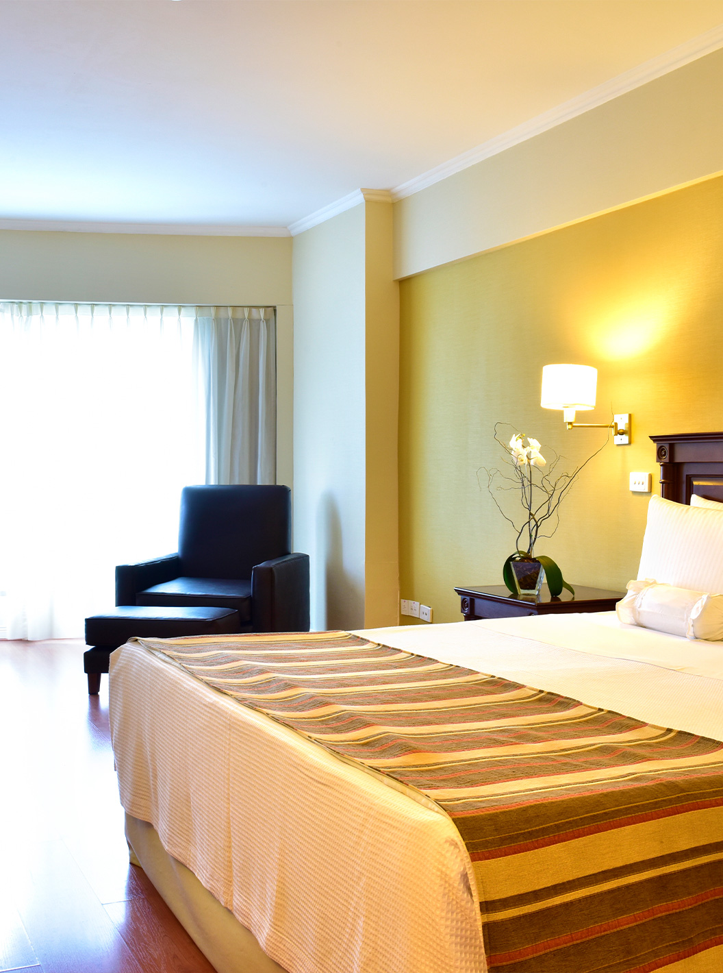 Das Queen Superior Zimmer im Pestana Buenos Aires hat ein Doppelbett, Nachttisch, einen Schreibtisch und einen Stuhl