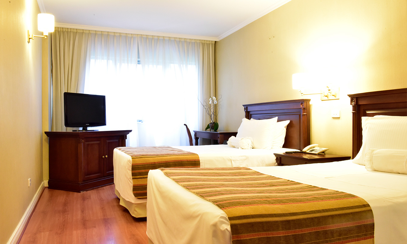 Das Twin Deluxe Zimmer im Pestana Buenos Aires hat zwei Einzelbetten, Nachttisch, Fernseher und Schreibtisch