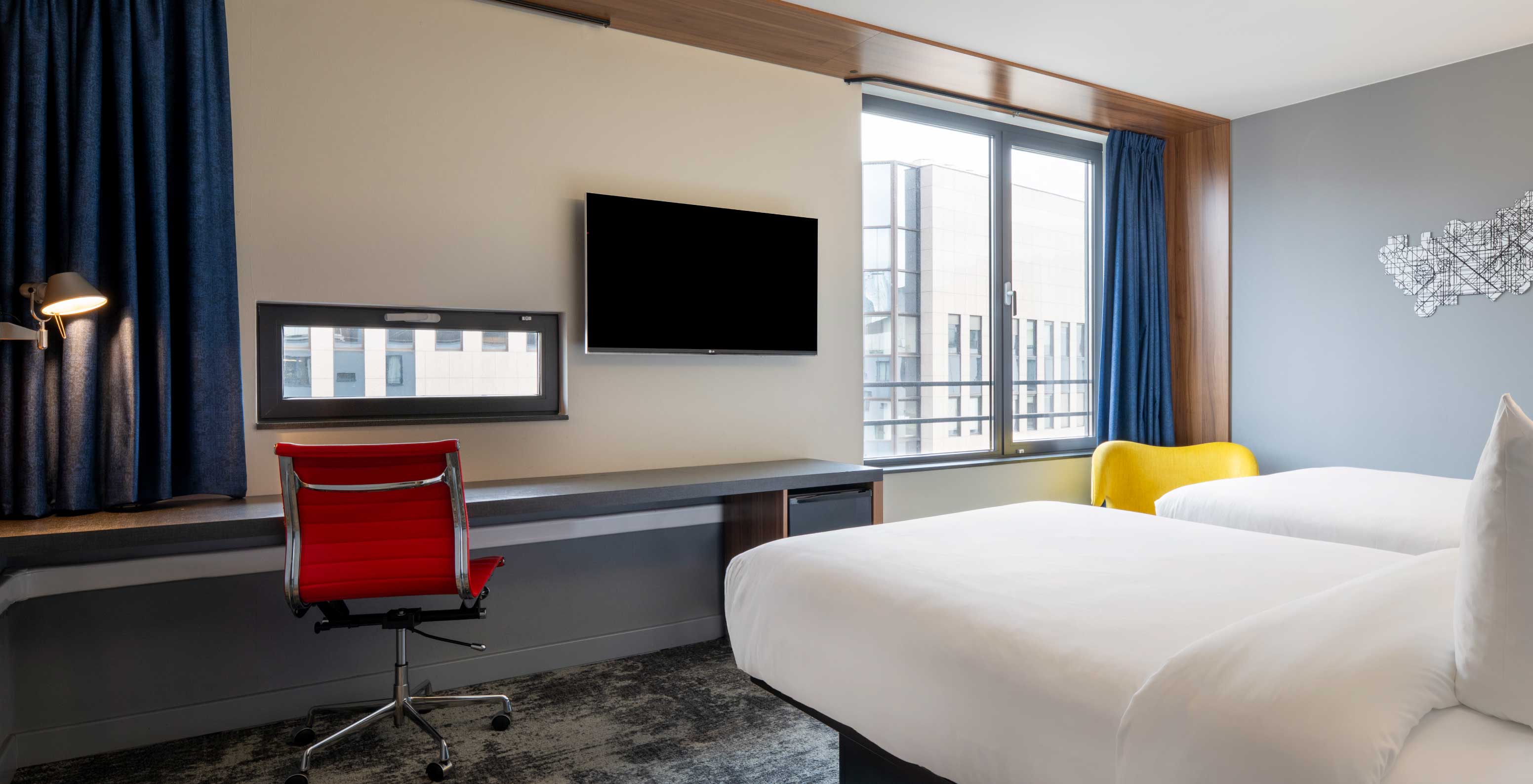 Das Standard Twin im Pestana Brussels verfügt über zwei Einzelbetten, zwei Fenster und einen an der Wand montierten Fernseher