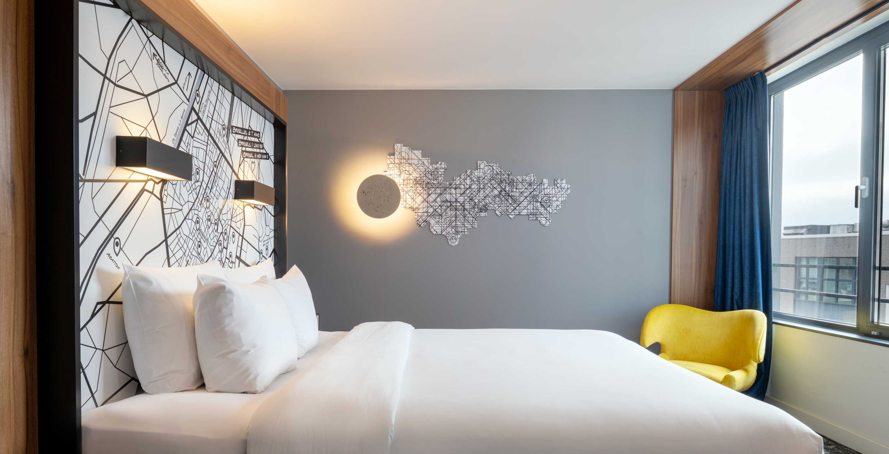 Das Superior King im Pestana Brussels Schuman verfügt über ein Doppelbett mit weißen Laken und eine Wandlampe