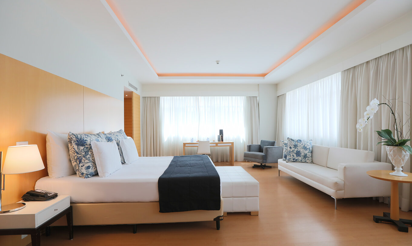 Die King Suite Executiva im Pestana Curitiba ist geräumig und hell mit Kingsize-Bett, Sofa und Schreibtisch