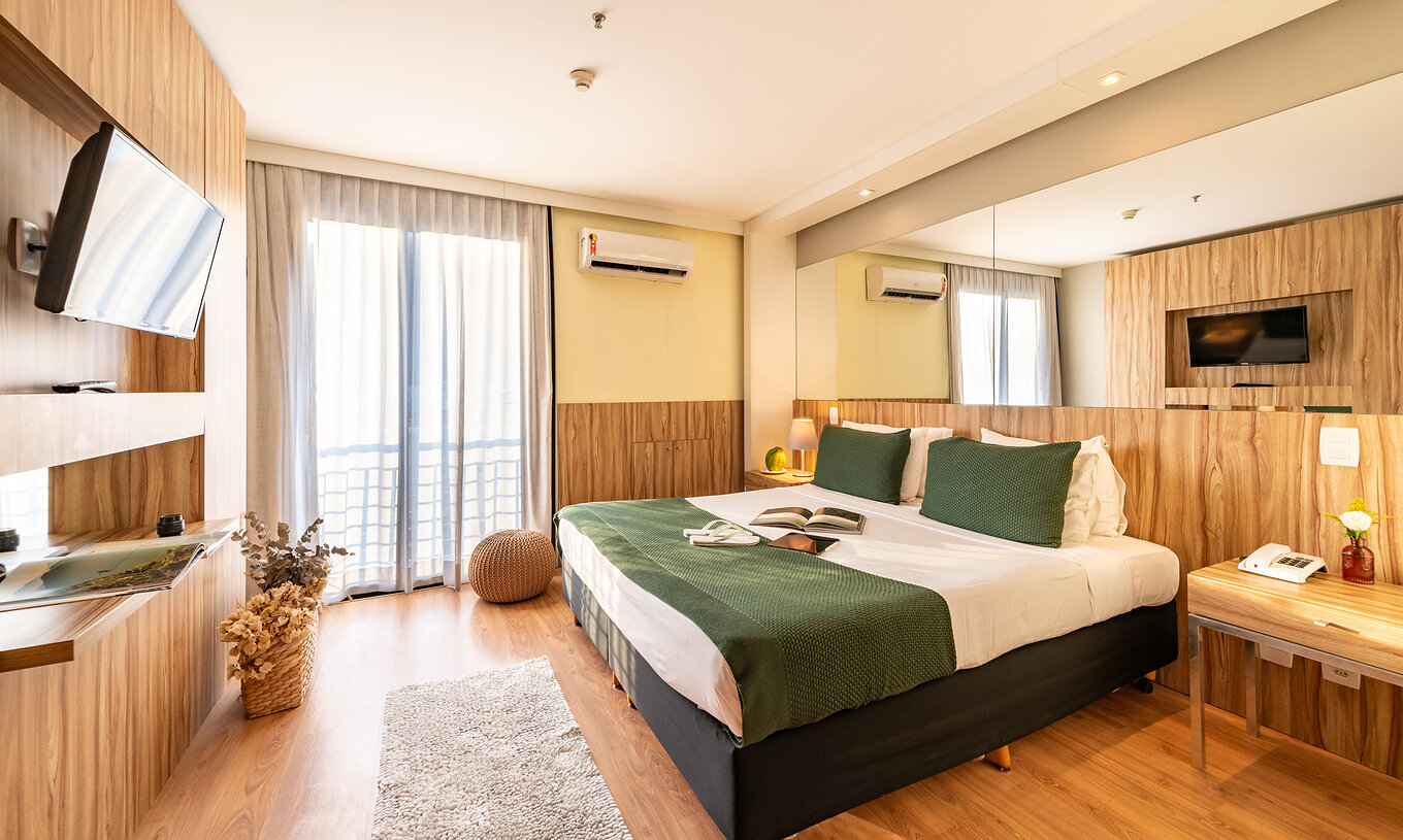 Die Suite mit seitlichem Meerblick hat ein Doppelbett mit Spiegel am Kopfende und einen Fernseher gegenüber 