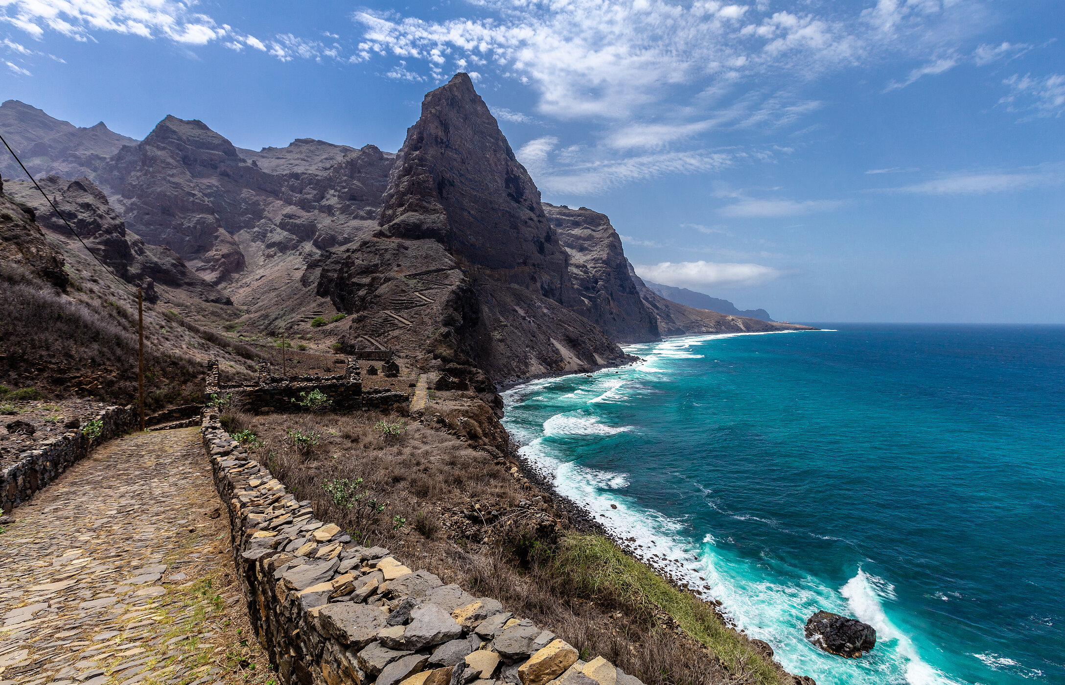 Steinpfad schlängelt sich entlang der Küste mit einer steilen Klippe auf der Insel Santo Antão, Kap Verde