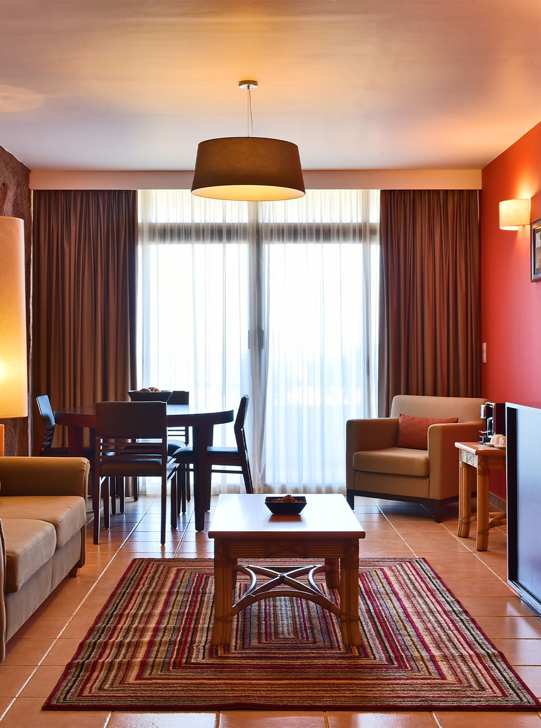 Suite Premium Pestana Tropico hat ein Wohnzimmer mit Sofa, Esstisch, Sessel und einem Couchtisch