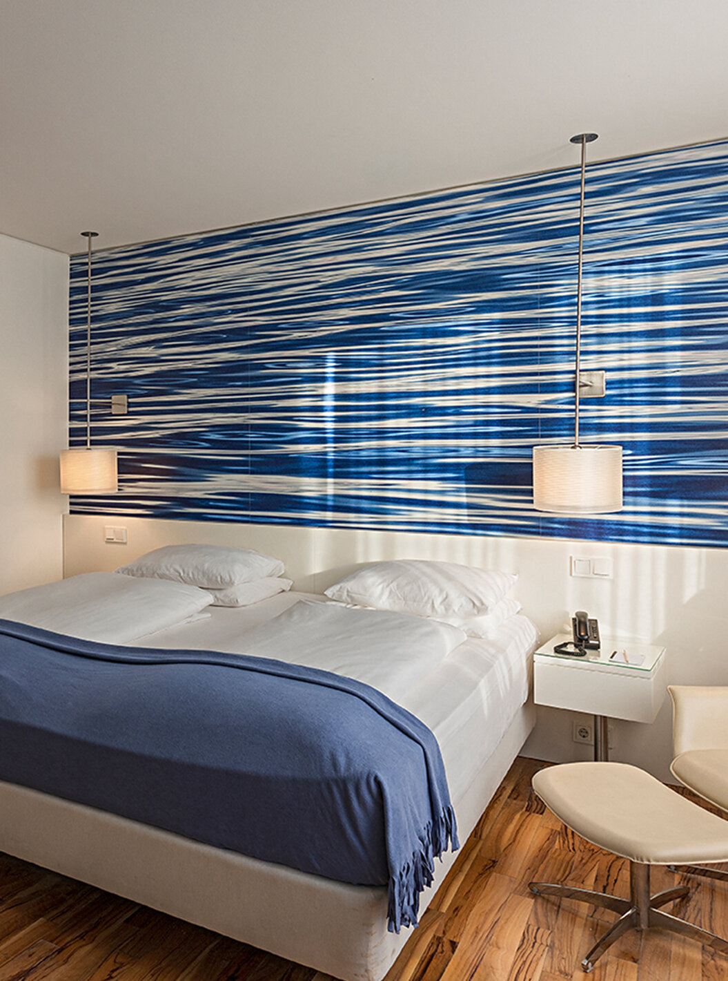 Das Deluxe Zimmer im Pestana Berlin Tiergarten hat ein Doppelbett, Nachttisch mit Telefon und ein Sofa