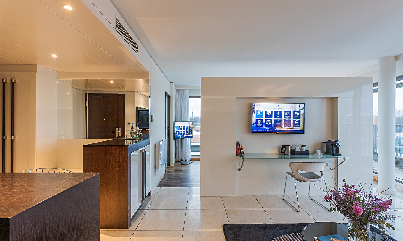 Die Panoramasuite im Pestana Berlin Tiergarten hat einen Schreibtisch mit Stuhl, Fernseher und Kaffeemaschine