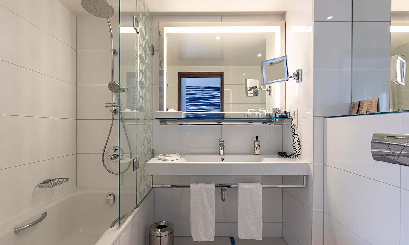 Das Premium Zimmer mit Balkon im Pestana Berlin Tiergarten hat ein Bad mit Dusche, ein Waschbecken und einen Spiegel