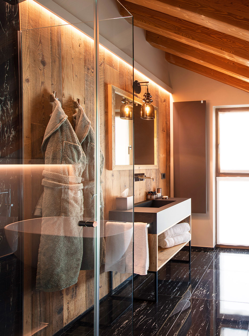 Suite Le Massif im Le Massif Courmayeur mit freistehender Badewanne unter Holzbalken und großem Fenster