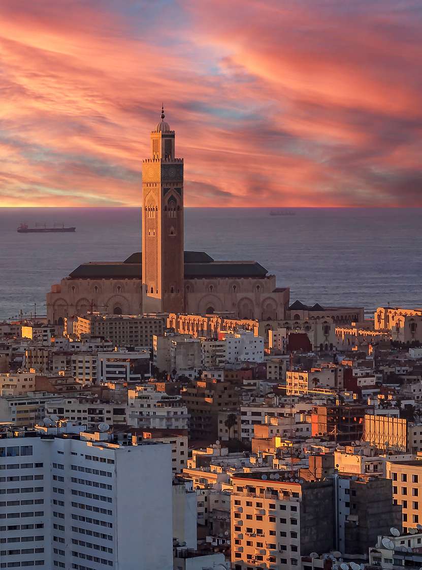 Luftaufnahme über Casablanca, Sonnenuntergang beleuchtet Gebäude, Himmel am Horizont, Meer und Turm