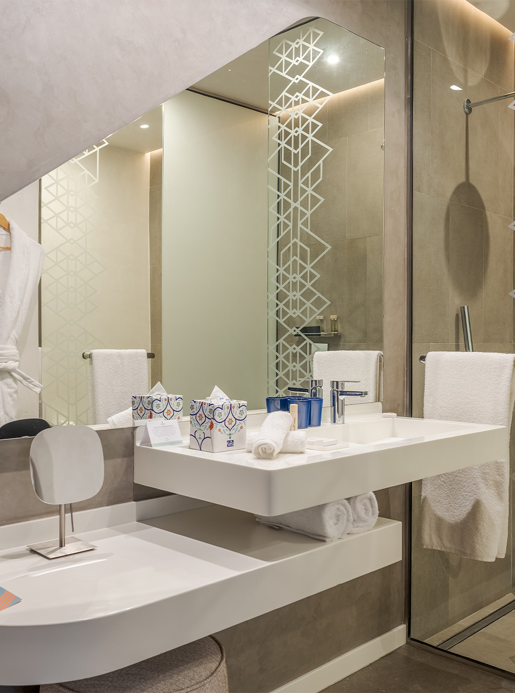 Die CR7 Junior Suite im Pestana CR7 Marrakeck hat ein Bad mit begehbarer Dusche, Waschbecken, Spiegel und Regal