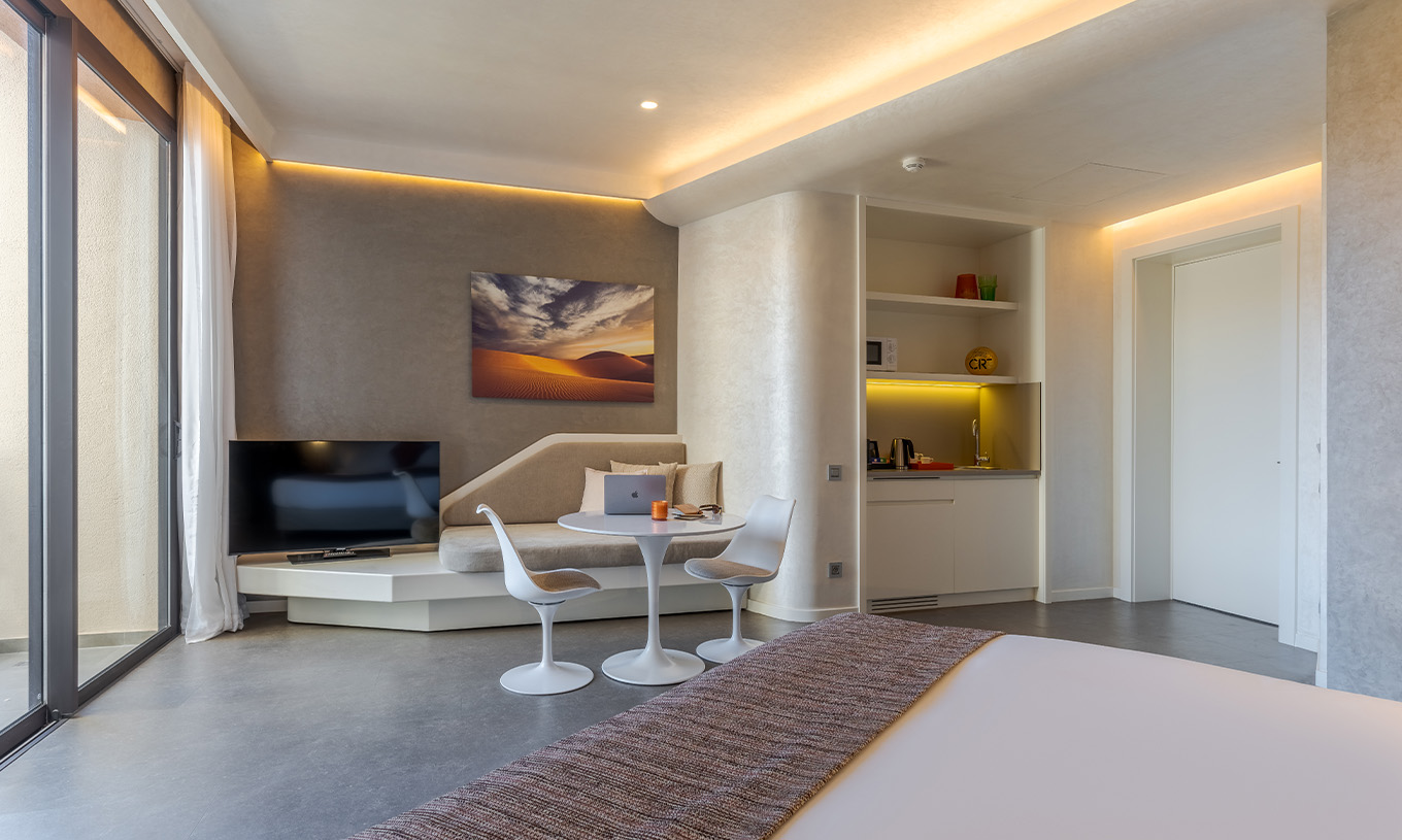 Das CR7 Zimmer Avenue im Pestana CR7 Marrakeck hat einen Fernseher, ein Sofa, einen Tisch, ein Spülbecken und Mikrowelle