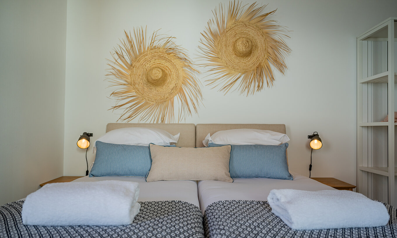 Die Standard Villa T2 im Pestana Comporta Village Residences verfügt über ein Doppelbett mit Strohdekoration an der Wand