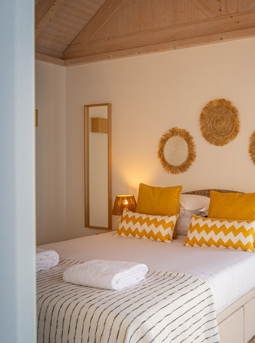 Die Superior Green Villa im Pestana Comporta Village Residences hat ein Schlafzimmer mit Doppelbett und gelben Kissen
