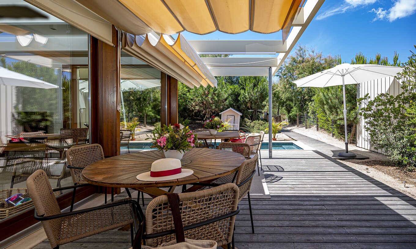 Aqua Villa Pestana Tróia Eco Resort hat eine Terrasse mit Tischen und Stühlen zum Entspannen