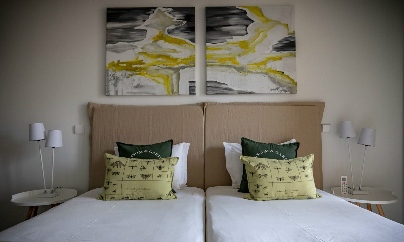 Apartment Eco Village Erdgeschoss Pestana Tróia Eco Resort hat zwei Betten und Bilder an der Wand