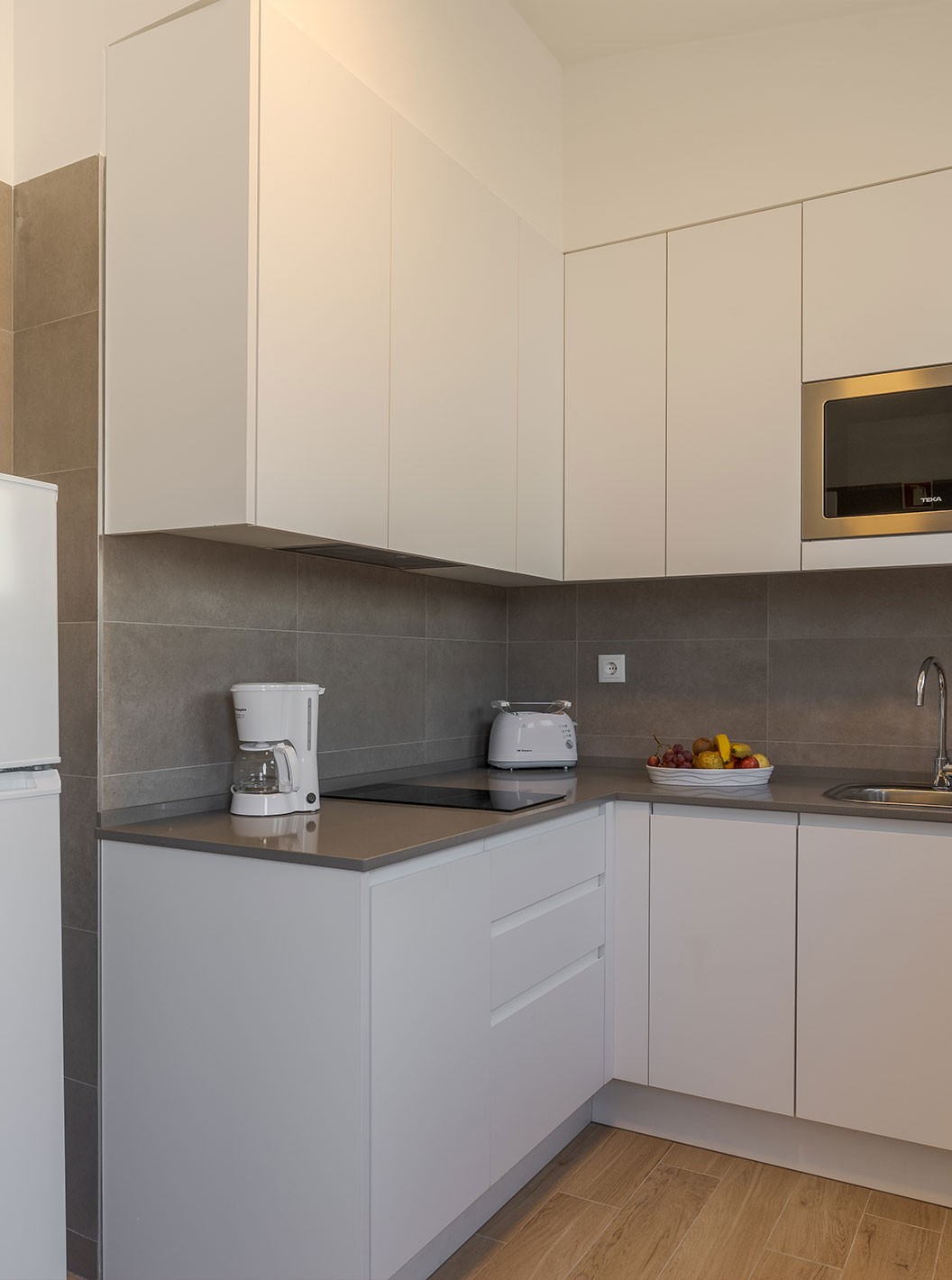 Die Villa 3 Zimmer Premium mit Meerblick hat eine Küche mit Kühlschrank, Herd, Mikrowelle und Toaster