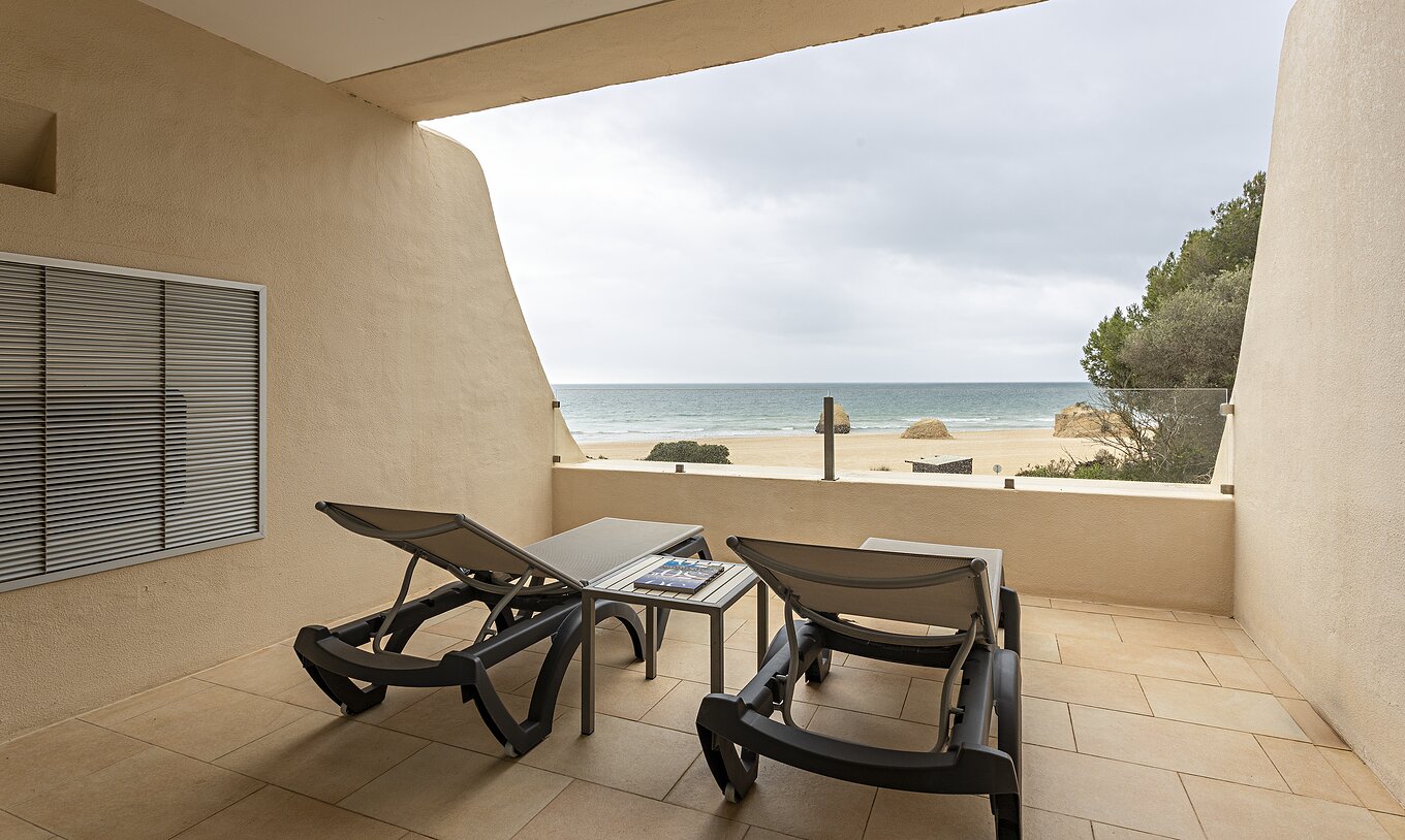 Die Cliff Suite T1 im Pestana Alvor Praia hat einen Balkon mit zwei Liegestühlen und Blick auf den Strand