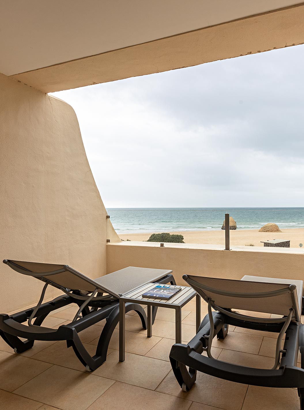 Die Cliff Suite T1 im Pestana Alvor Praia hat einen Balkon mit zwei Liegestühlen und Blick auf den Strand