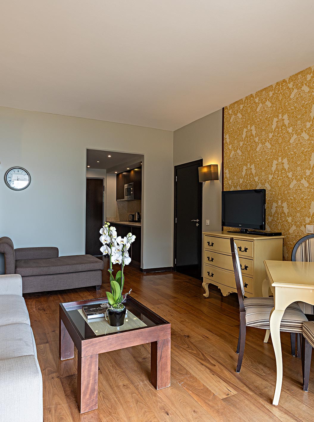 Die Cliff Suite T1 im Pestana Alvor Praia hat ein Wohnzimmer mit Fernseher und einen Balkon mit Tisch, Stühlen und Meerblick