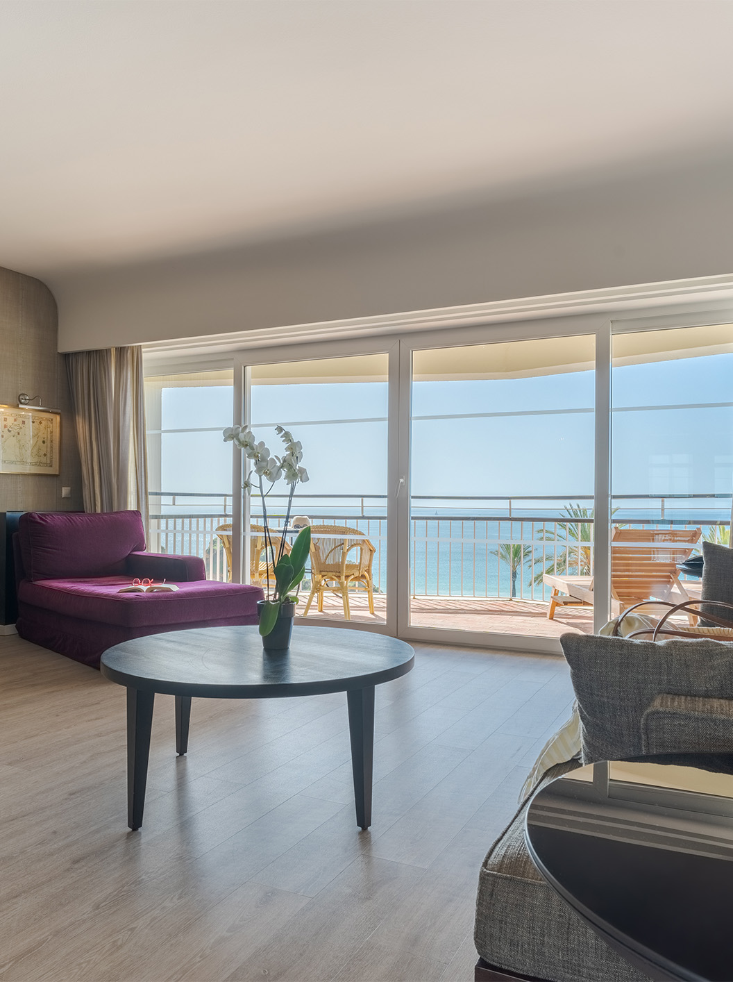 Die Luxussuite mit Meerblick im Pestana Alvor Praia hat ein Wohnzimmer mit Sofa, Sessel, Tisch, Fernseher und Balkon