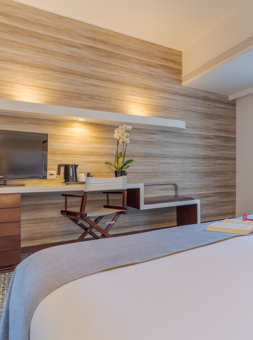 Das Deluxe im Pestana Alvor Praia hat ein Doppelbett, Fernseher am Schreibtisch, blauen Sessel und Fenster