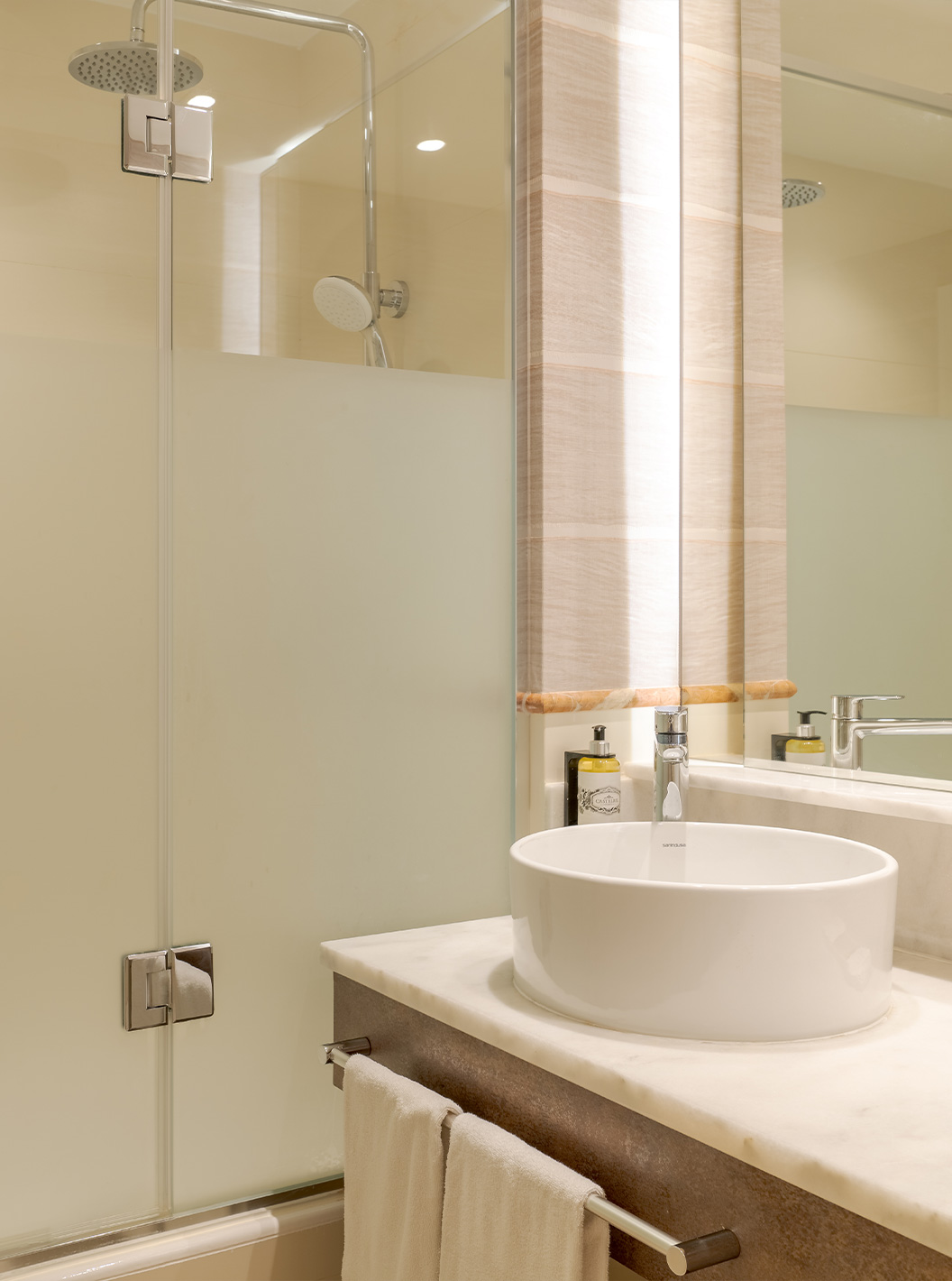 Das Familienzimmer im Pestana Blue Alvor Beach hat ein Bad mit Waschbecken, Spiegel, Handtüchern und Dusche