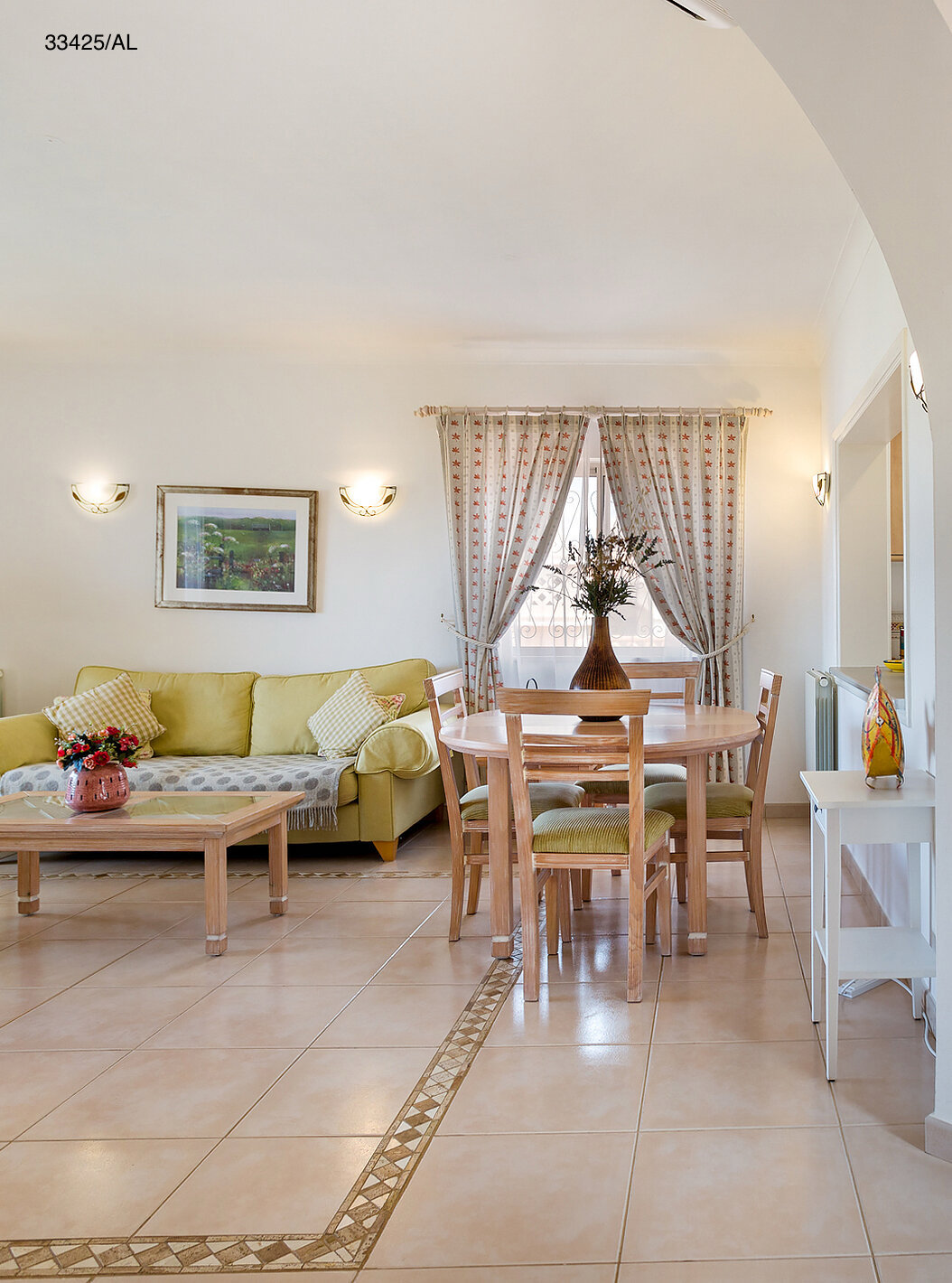 Die Wohnung Pestana Carvoeiro Golf T2 Standard hat ein Wohnzimmer mit grünen Sofas und einem Tisch mit Stühlen