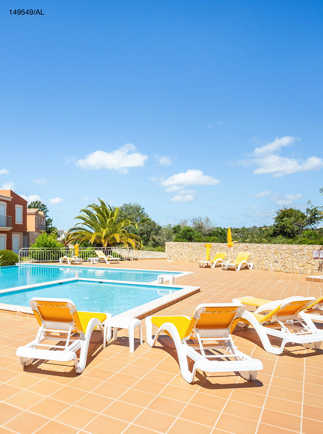 Die Wohnung Pestana Carvoeiro Golf T2 Superior hat einen Außenbereich mit Pool und gelben Liegestühlen
