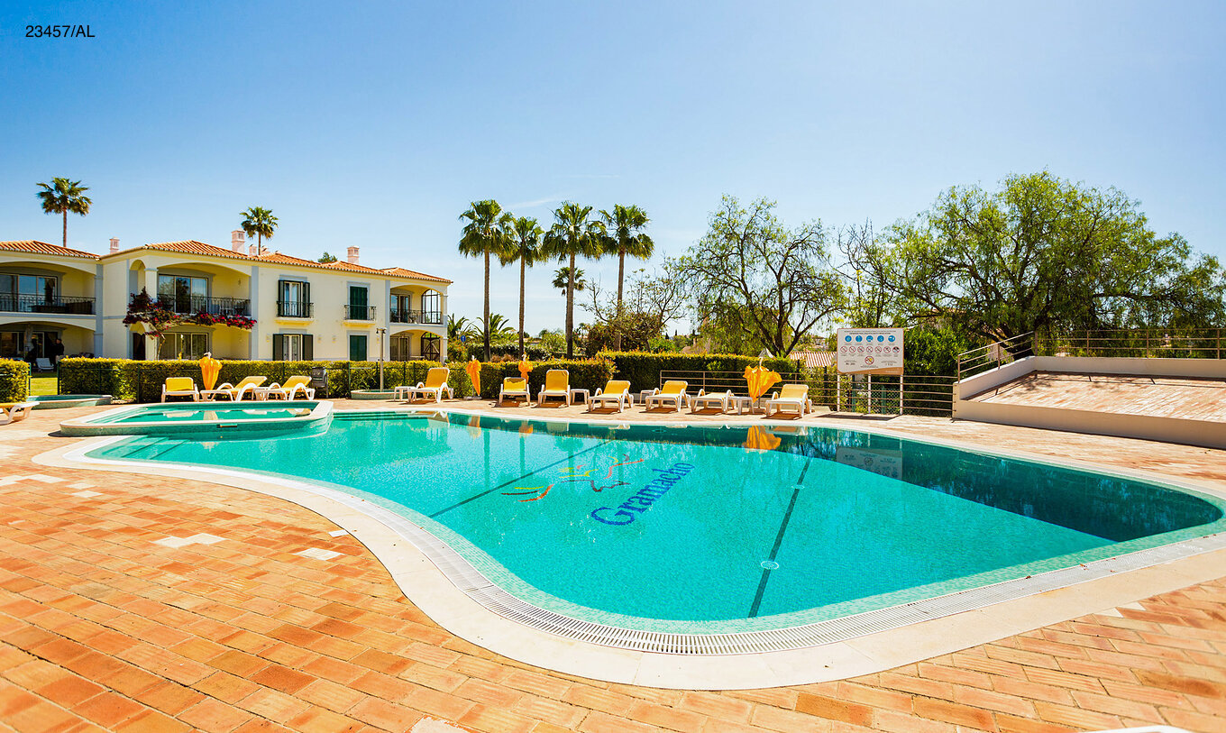 Die Wohnung Pestana Carvoeiro Golf T3 Standard hat einen Außenbereich mit Pool und gelben Liegestühlen