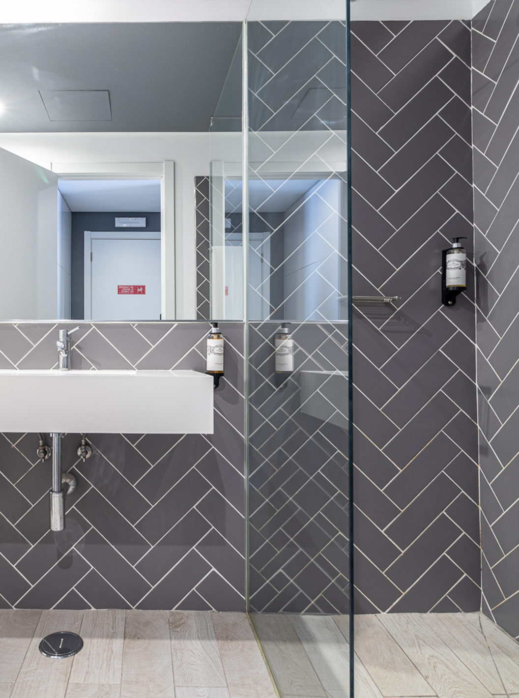 Das Klassikzimmer mit Poolblick hat ein modernes Bad mit weißem Waschbecken, Spiegel und Glasdusche