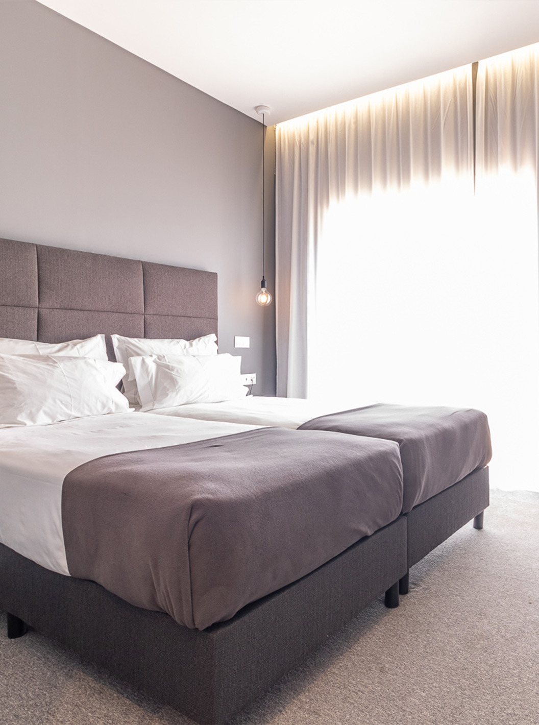 Das Klassikzimmer mit Poolblick im Pestana Gramacho ist modern mit zwei Betten, grauen Vorhängen und Blumentisch