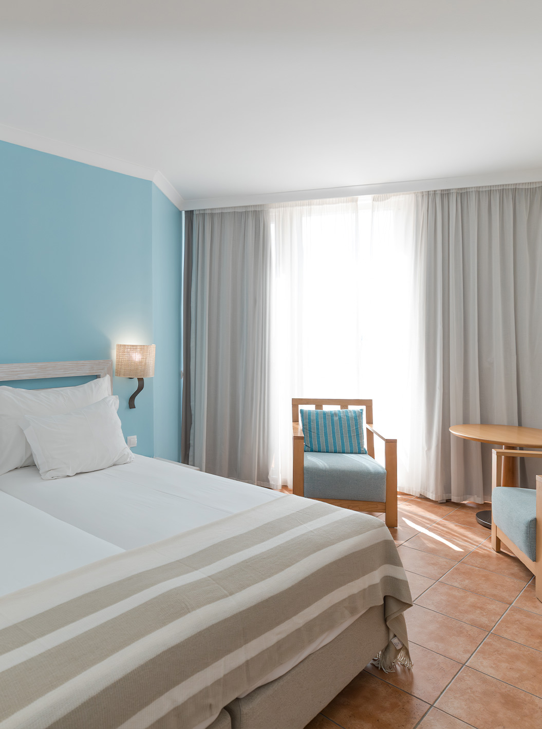 Das Deluxe Meerblick im Pestana Viking hat zwei Betten, Nachttisch, zwei Sessel und Klimaanlage