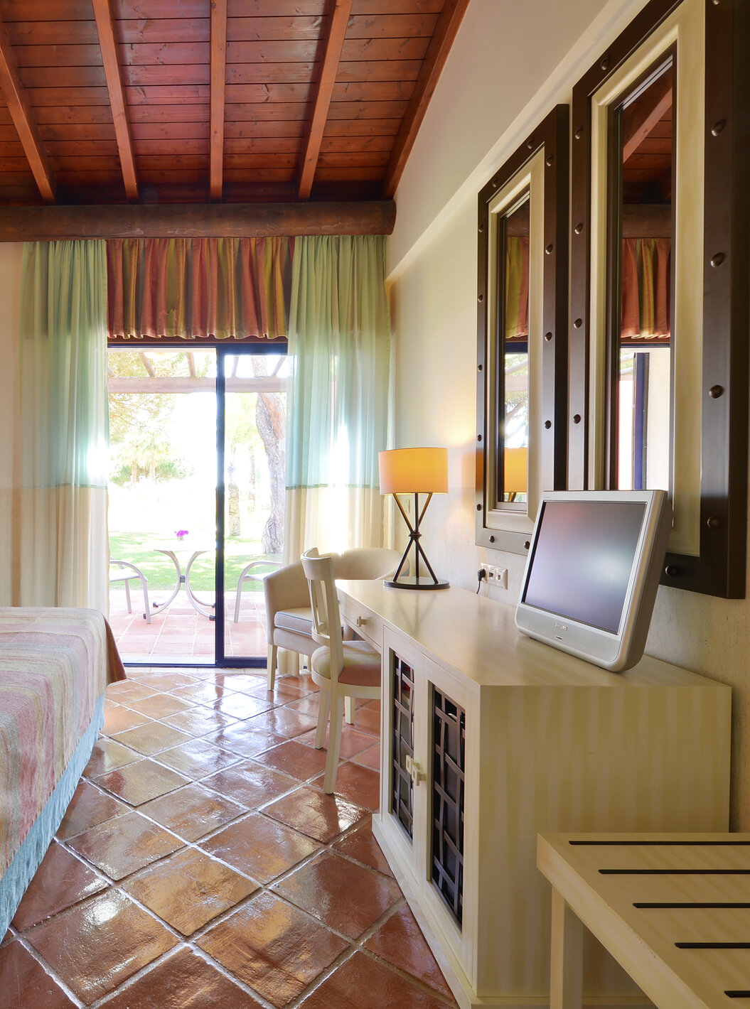 Die Gartenblick Suite Vila Sol im Pestana Vila Sol - Vilamoura hat ein Schlafzimmer mit Doppelbett, Spiegel und Balkonfenster