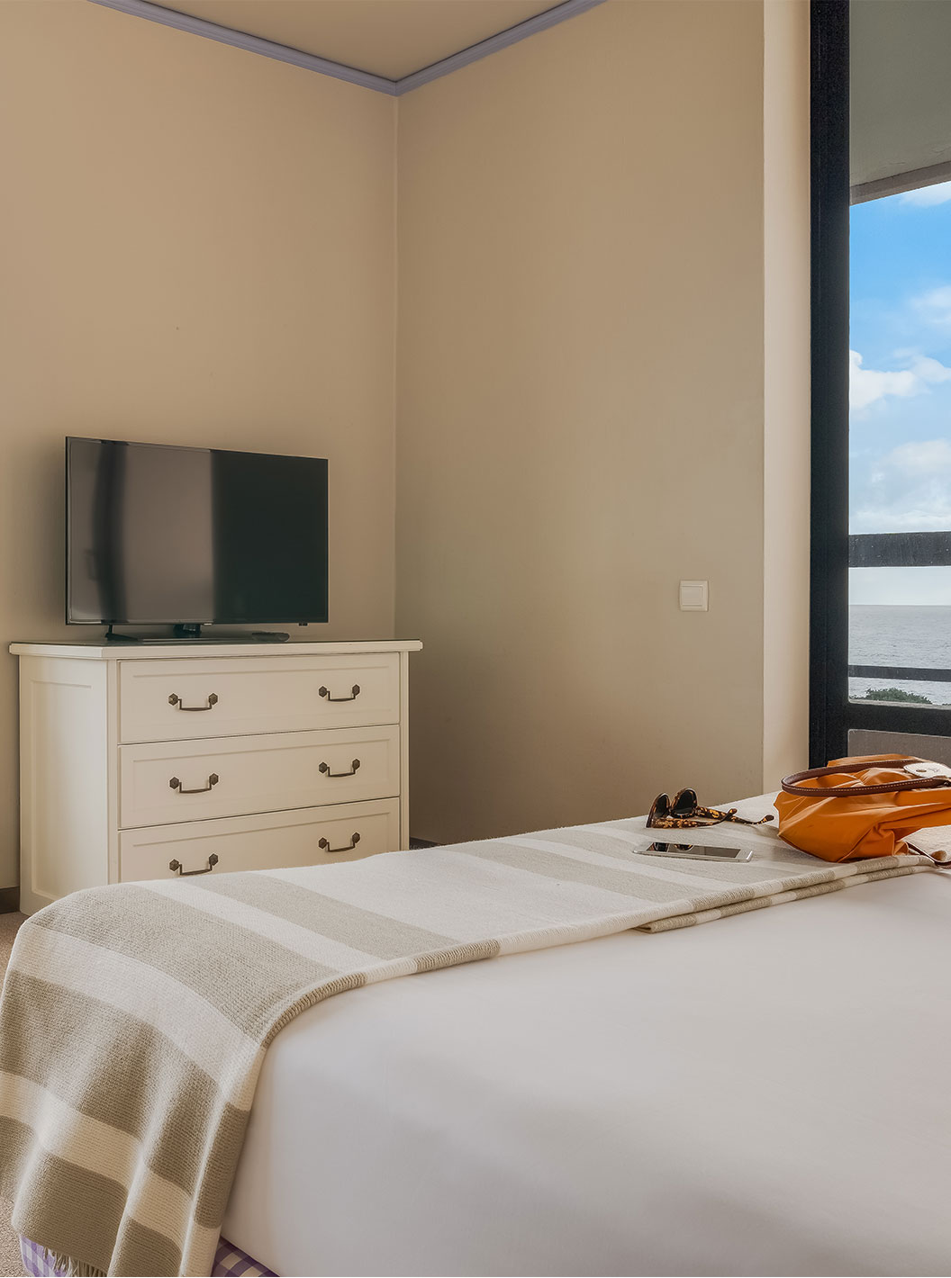 Das Standard Meerblick Zimmer im Pestana Bahia Praia hat zwei Fenster mit Meerblick und grüner Landschaft
